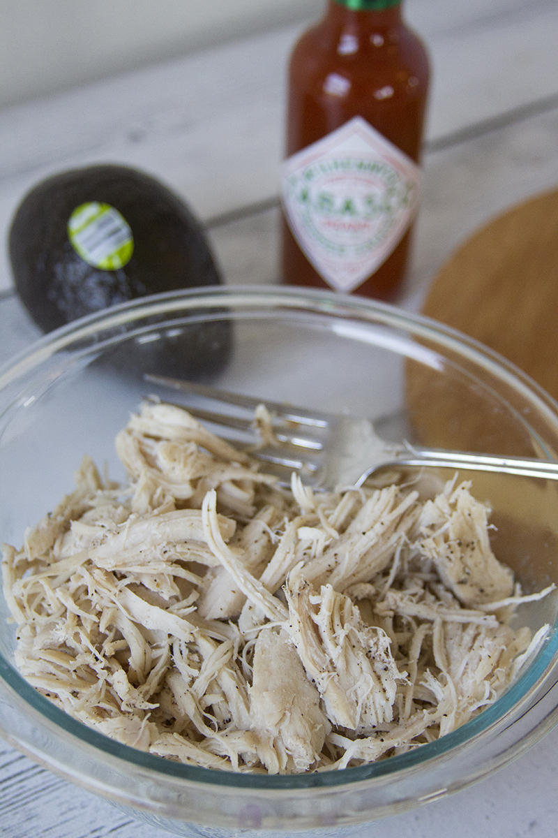 These Spicy Ranch Chicken Sliders are so easy to make and they are delicious. That makes them our go-to whenever we need game day food. This recipe will make 12 sliders. We usually have a little extra chicken mixture, but my kids never complain because the extras make AMAZING nachos. This can easily be doubled for a crowd. Spicy Ranch Chicken Sliders with Avocado Ingredients 3-4 chicken breasts 2 Avocados From Mexico, sliced 3/4 cup TABASCO® Sauce (you can do more or less based on your family's personal preference) 1 ounce pack of powdered ranch mix 1 8 oz. package of cream cheese Everything seasoning (or any combination of your favorite) 2 Tbsp. butter, melted 12 dinner rolls Spicy Ranch Chicken Sliders with Avocado Ingredients Cook the chicken breasts, seasoning liberally with pepper and a bit of salt. My favorite way to do this is in my Instant Pot. I put about a cup of water in the bottom, put in the metal rack that comes with the pot, and layer the chicken on top of the rack. Set it to the poultry setting to cook. This essentially steams the chicken and the texture is perfect. Once your chicken is cooked, shred it well.