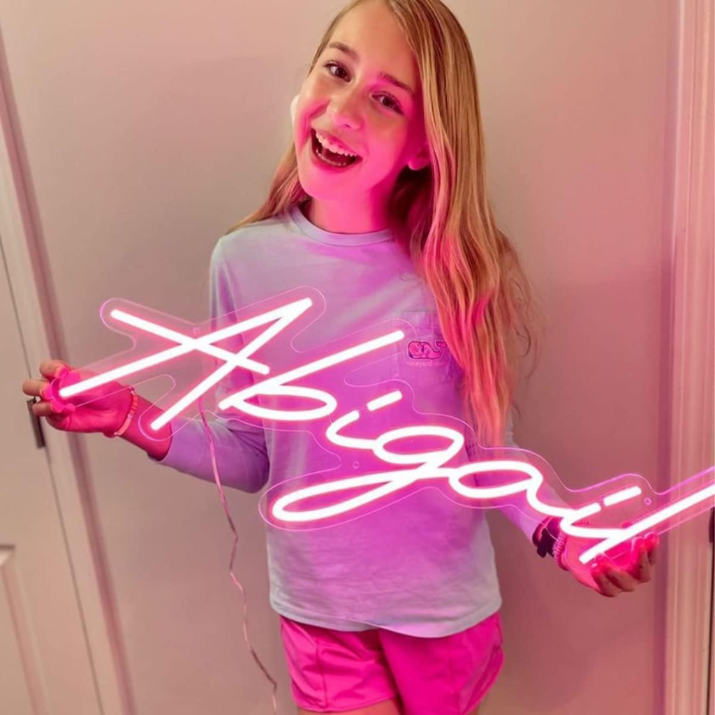 a girl holding a pink sign